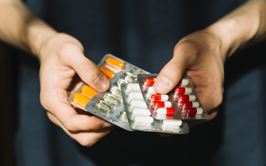 Close-up of a person holding prescription pills.