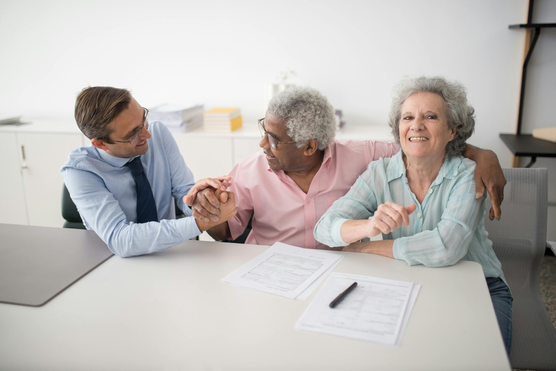 An insurance agent sitting next to smiling clients.
